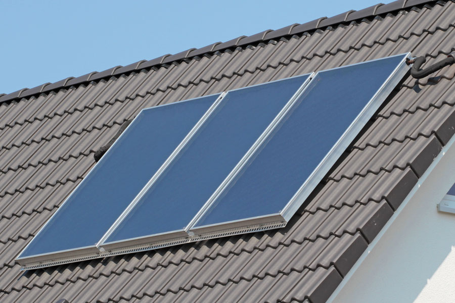 hewa-flachkollektor Solarthermie-Flachkollektoren auf einem Hausdach zur umweltfreundlichen Erwärmung von Wasser und Heizungsunterstützung.